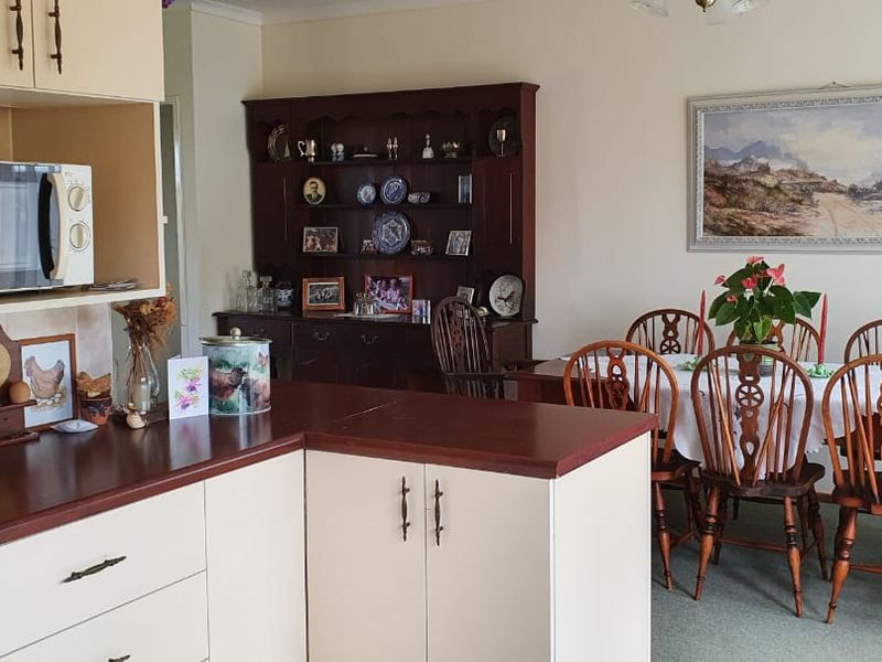 Open plan kitchen and dining area featuring built-in cabinetry with laminate countertops, providing a functional layout for daily living and dining.