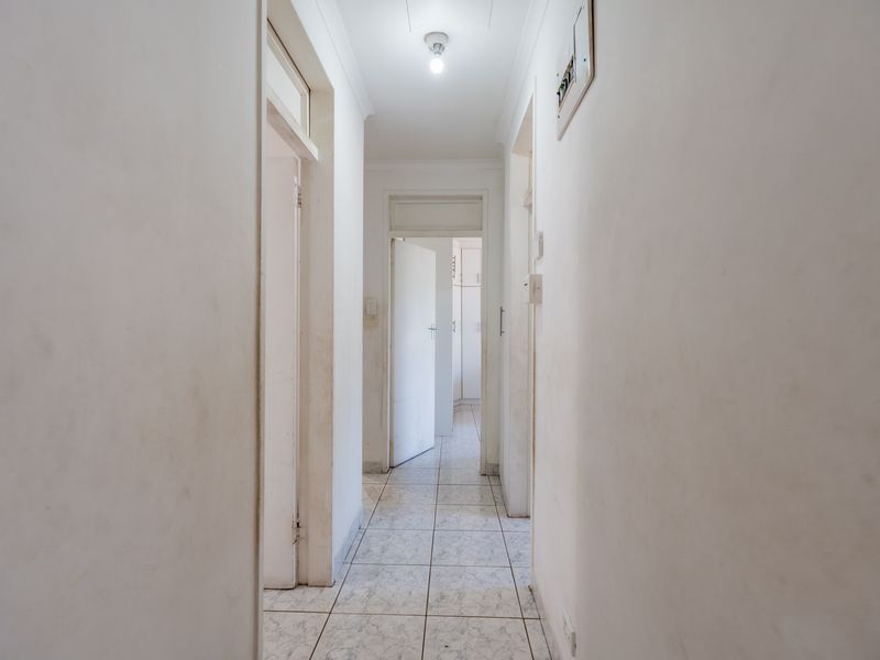 A functional hallway featuring tiled flooring and multiple doorways leading to adjacent rooms, providing central access throughout the home.