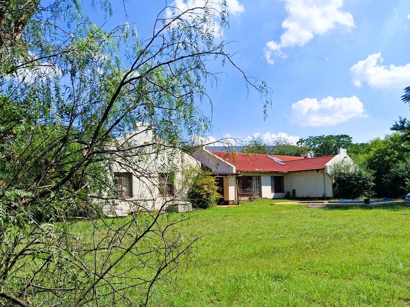 A view of the rear exterior of the townhouse, featuring a red tiled roof, cream-colored walls, and a spacious garden area.