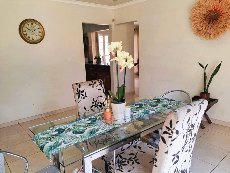 A dining area featuring tiled flooring and a view through to the kitchen, providing a functional space for meals.