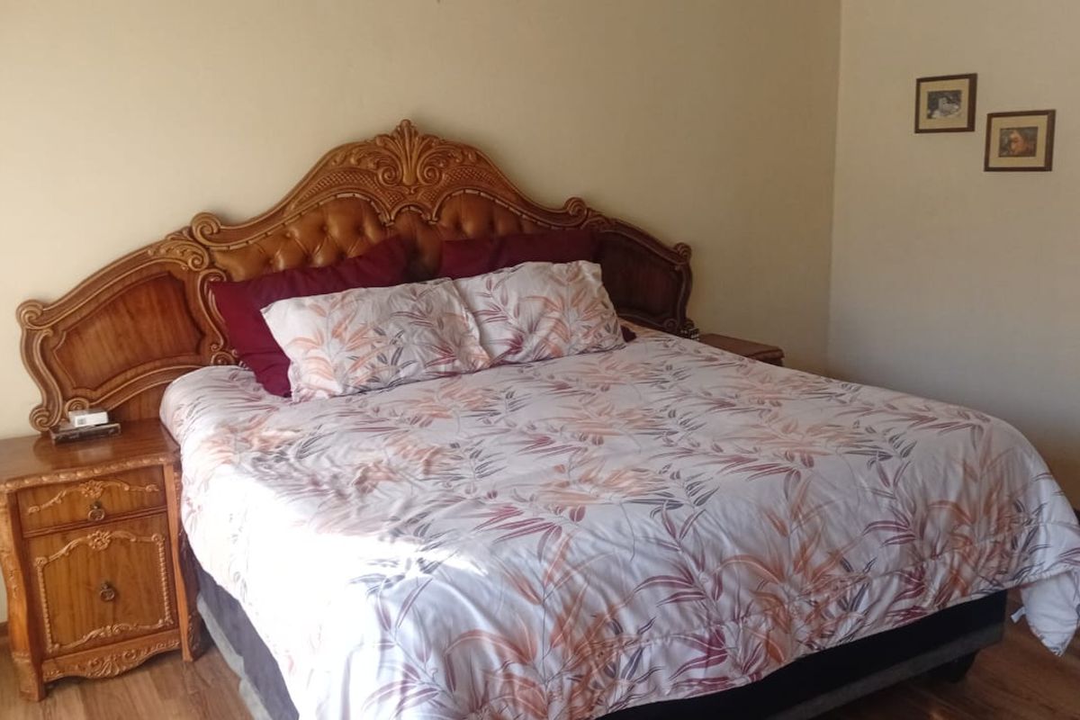 A bedroom featuring wood-look flooring and neutral wall tones, providing a comfortable and functional sleeping space.