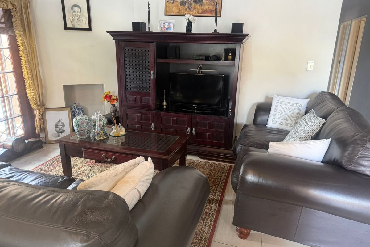 A living room featuring tiled flooring and a glass-paneled door leading to an outdoor area.