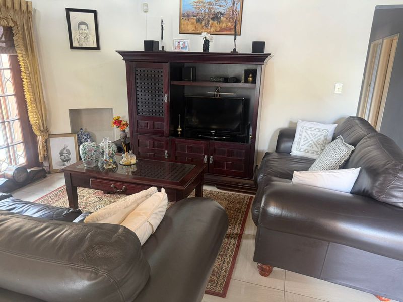 A living room featuring tiled flooring and a glass-paneled door leading to an outdoor area.