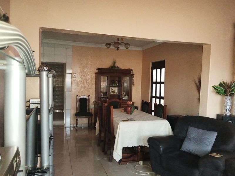 Open plan living and dining area featuring tiled flooring and coved ceilings, offering a functional layout with direct access to adjacent spaces.