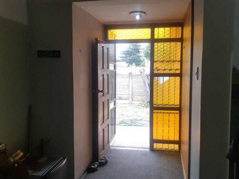 Entrance hall featuring a timber front door with decorative amber glass sidelights, providing direct access to the exterior garden area.