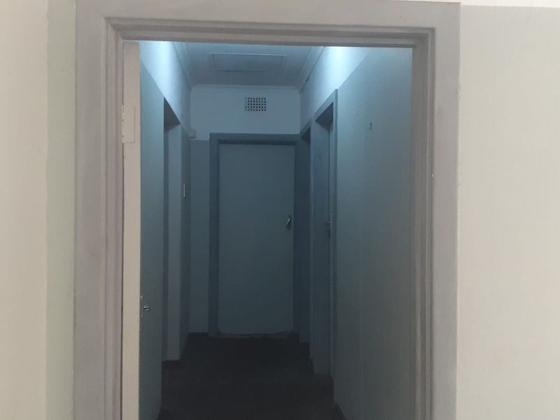 A functional interior hallway connecting multiple rooms, featuring standard door frames and neutral wall finishes.