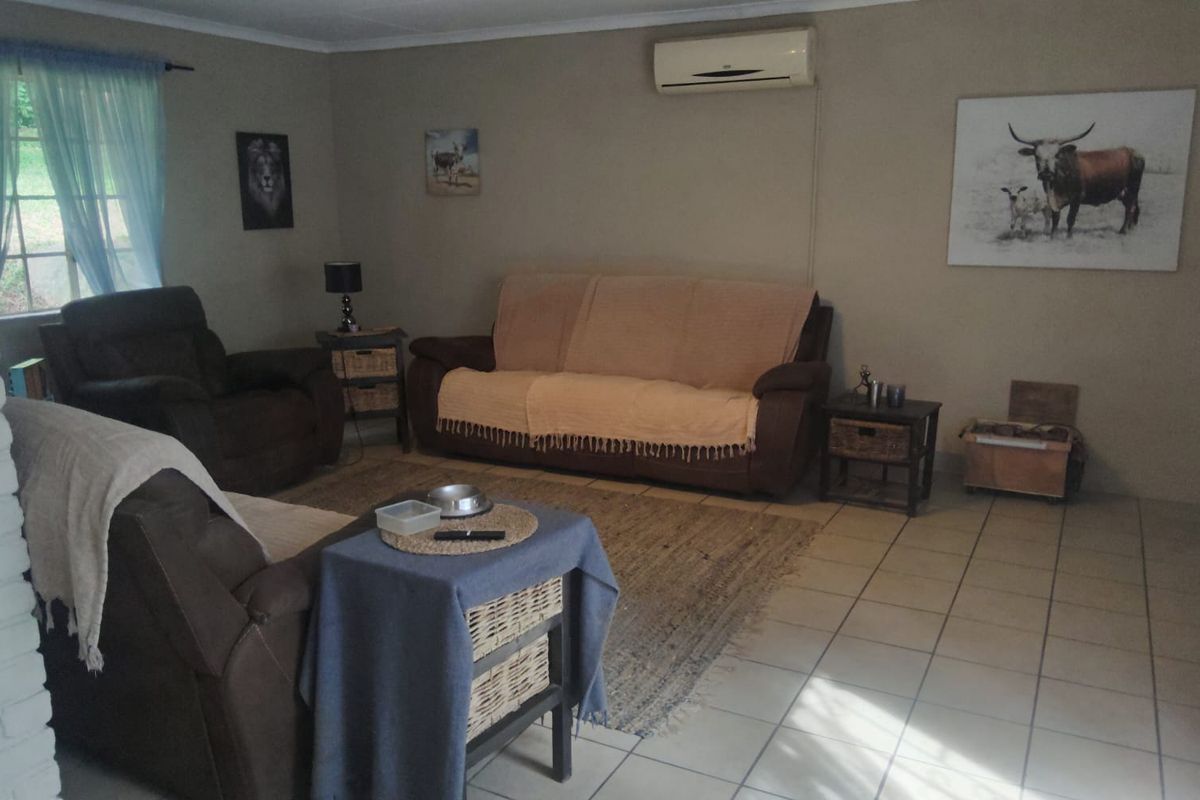 A comfortable living room featuring tiled flooring and a wall-mounted air conditioning unit, providing a functional and relaxed space.