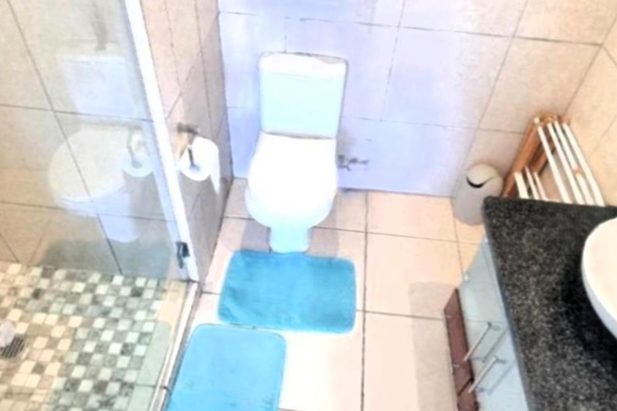 A compact bathroom featuring a glass-enclosed shower, a modern vessel sink set on a granite vanity, and a standard toilet.