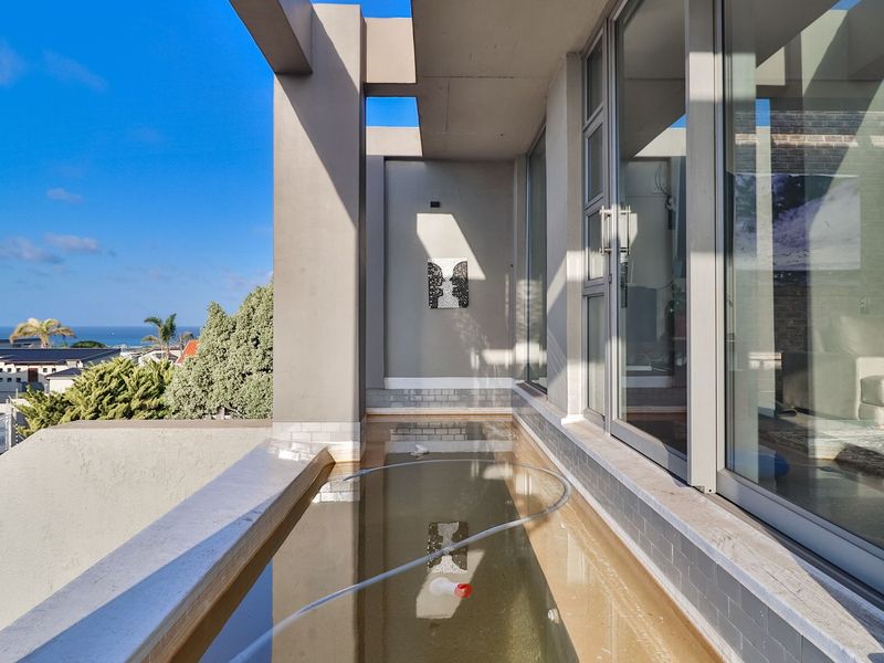 Modern balcony featuring a built-in plunge pool, large sliding glass doors, and expansive coastal views.
