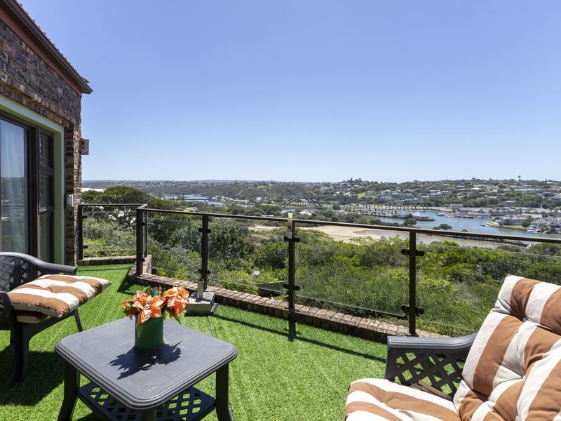 Elevated balcony featuring a glass balustrade and artificial turf, offering expansive panoramic views of the surrounding landscape and river.