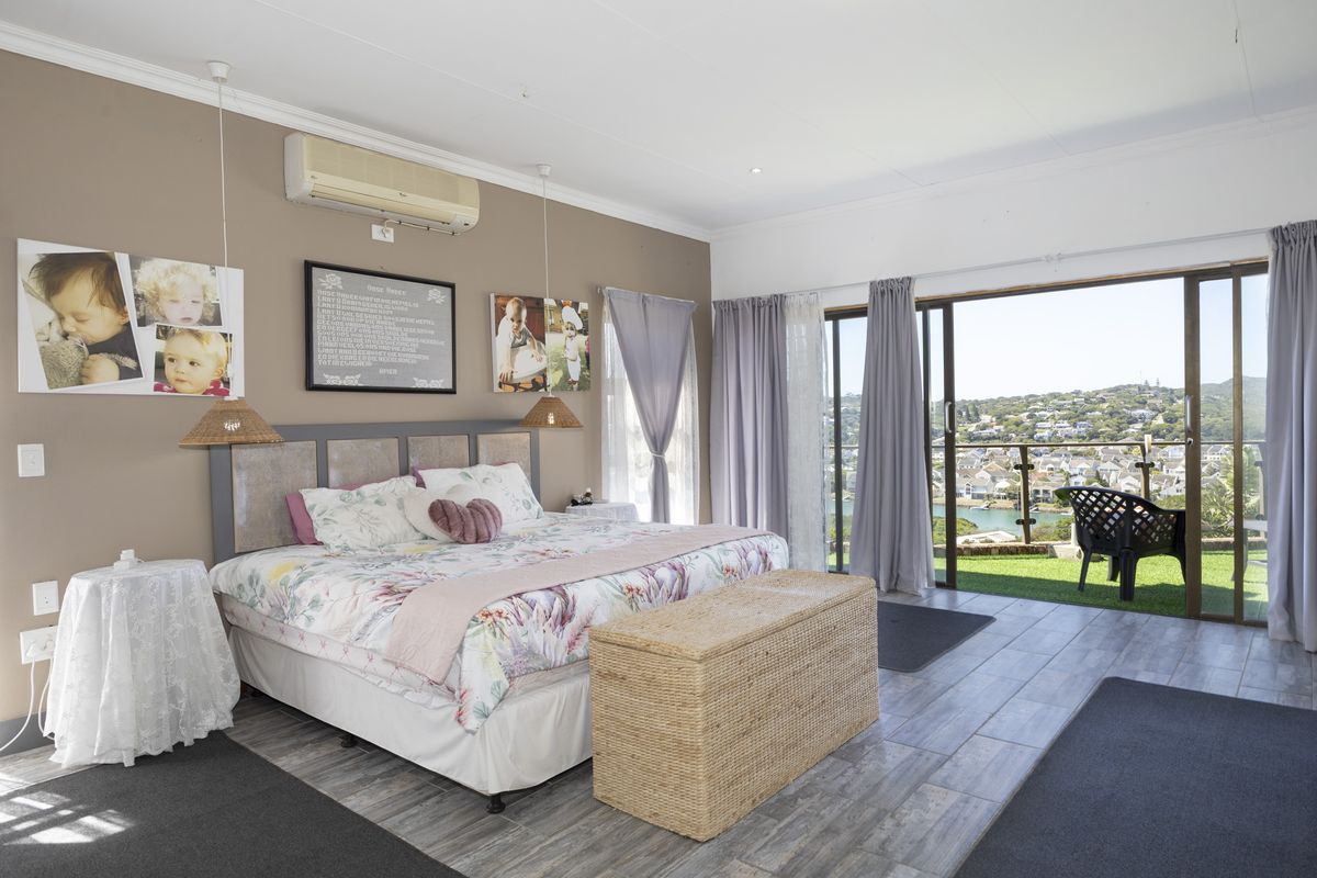 Spacious bedroom featuring tiled flooring, air conditioning, and large sliding glass doors opening onto a balcony with scenic views.