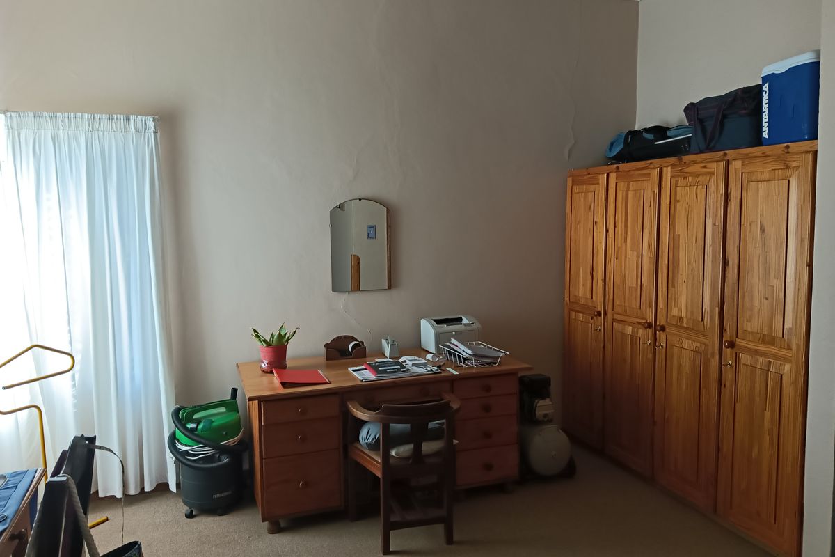 A bedroom featuring built-in wooden cupboards and carpeted flooring, providing functional storage space.