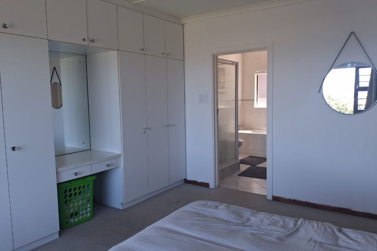 Bedroom featuring extensive built-in cabinetry with integrated vanity and direct access to an en-suite bathroom.