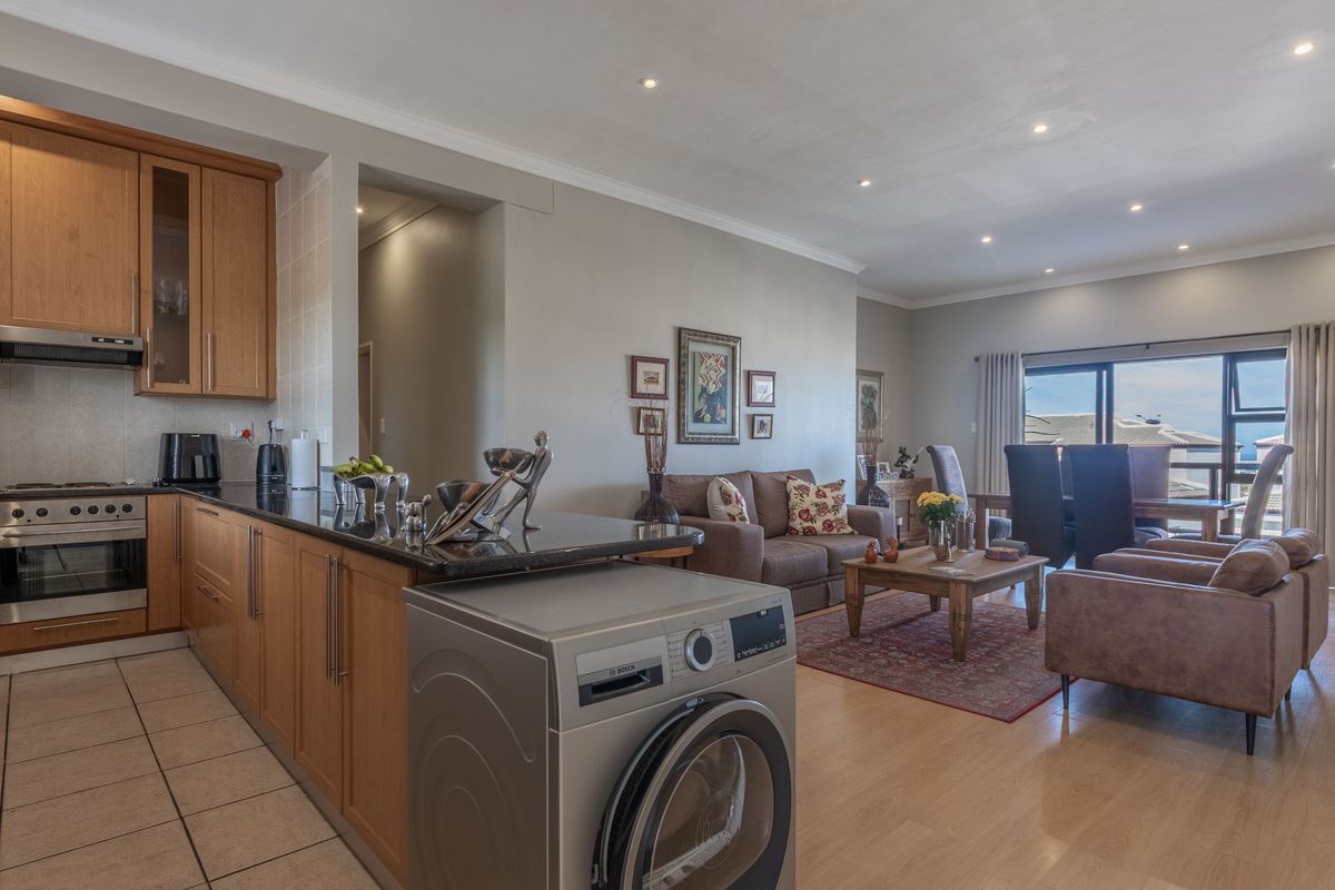 Spacious open-plan living area featuring a functional kitchen with granite countertops, integrated appliances, and seamless flow to the dining and lounge space.