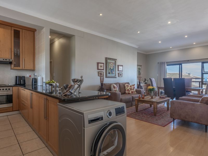 Spacious open-plan living area featuring a functional kitchen with granite countertops, integrated appliances, and seamless flow to the dining and lounge space.