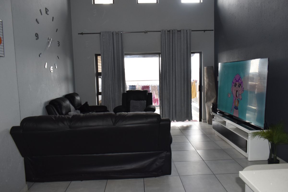Spacious living room featuring high ceilings, clerestory windows, and large sliding glass doors that provide access to an outdoor area.