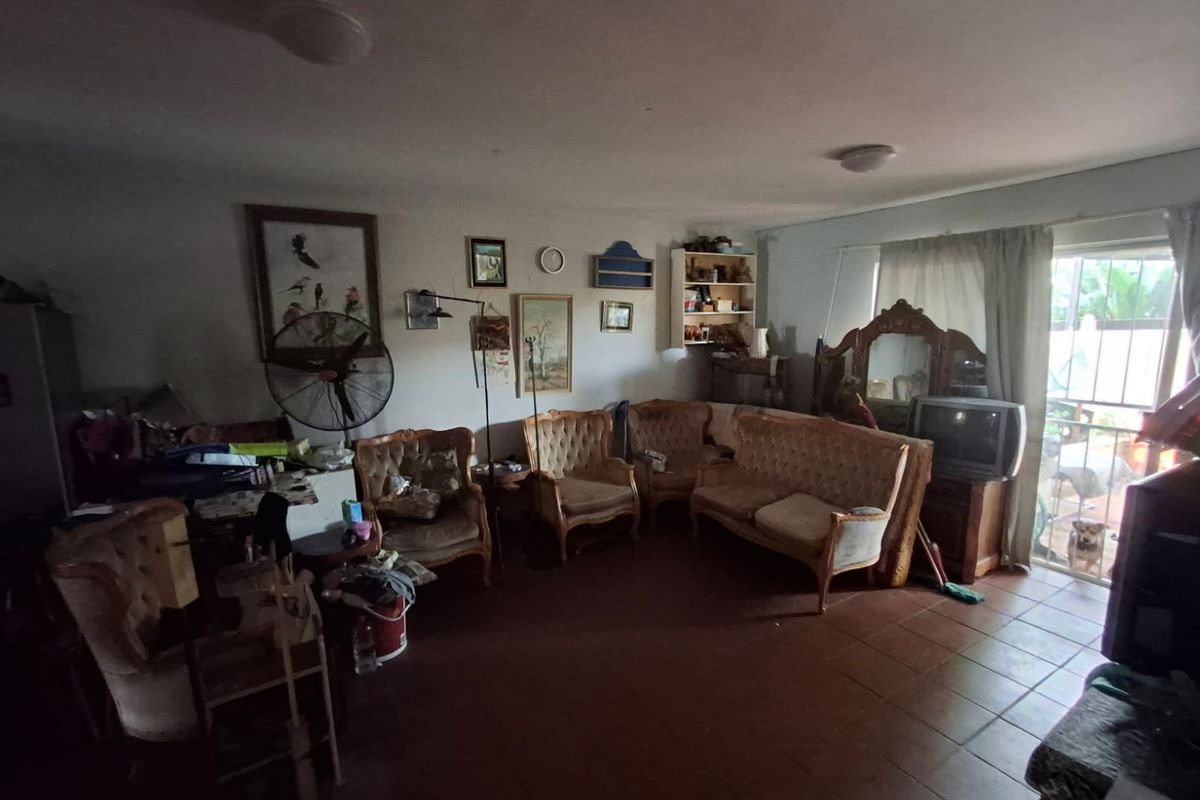 A spacious living area featuring tiled flooring and a sliding glass door providing access to the exterior.