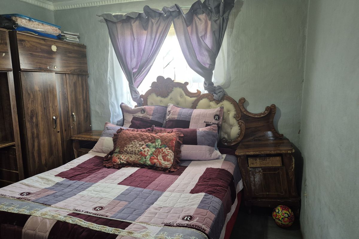 A bedroom featuring a window with curtains and built-in style cabinetry, providing a functional sleeping space.