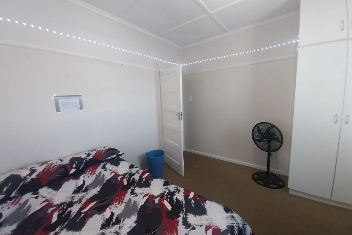 A bedroom featuring built-in white cabinetry and carpeted flooring.