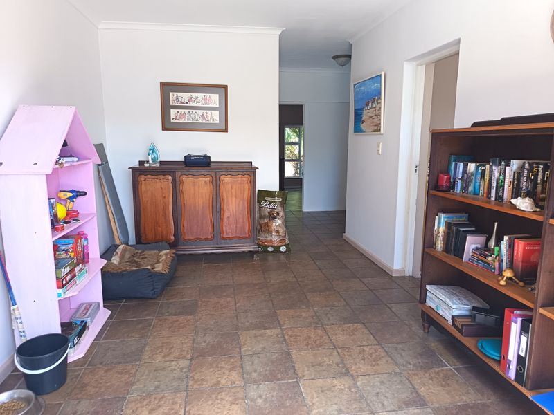 A spacious hallway featuring durable tiled flooring and neutral wall finishes, providing a central access point to other areas of the home.