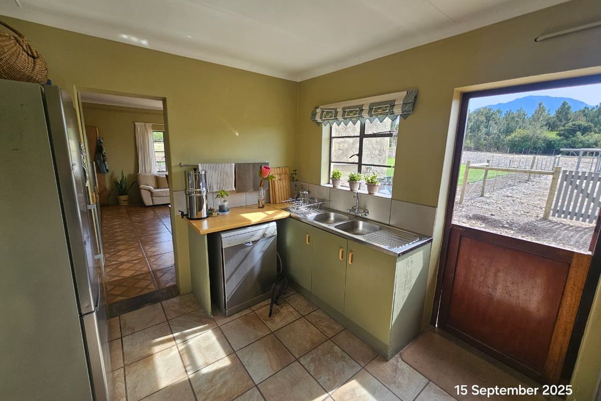 A functional kitchen featuring built-in cabinetry, a double stainless steel sink, and direct access to the outdoor area.