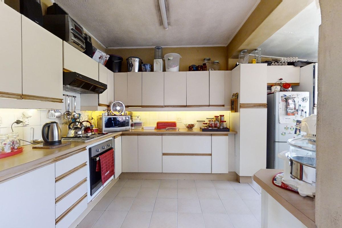 A functional kitchen featuring built-in cabinetry, laminate countertops, an integrated oven, and under-cabinet lighting, offering a practical layout for daily meal preparation.