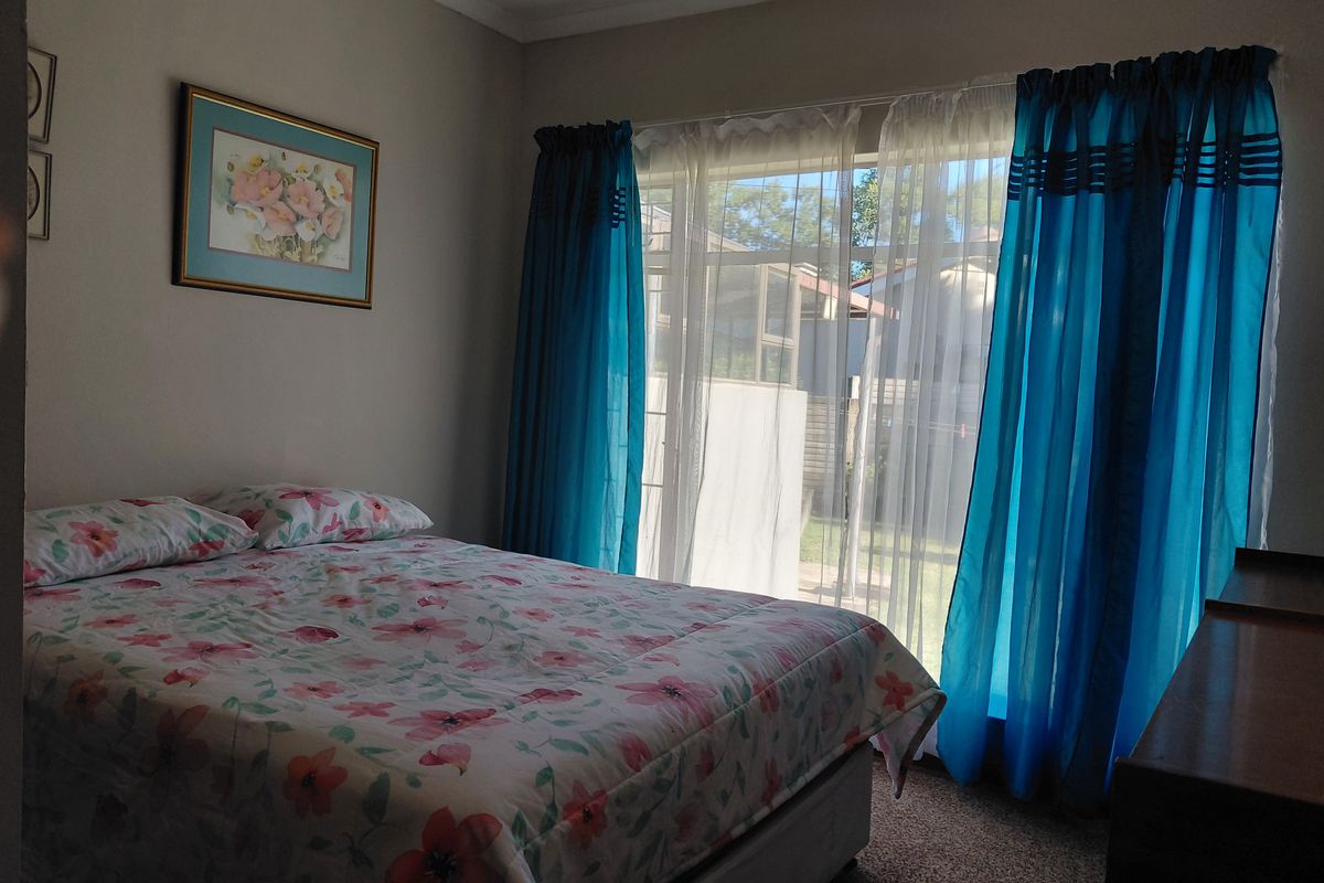 A bedroom featuring carpeted flooring and a sliding glass door providing access to the exterior.