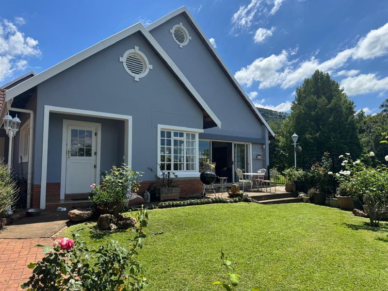 Rear view of the house featuring a well-maintained lawn, brick patio area, and sliding glass doors leading into the home.