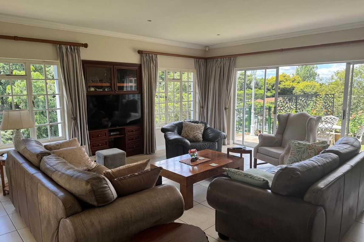 Spacious living room featuring built-in cabinetry, tiled flooring, and large sliding glass doors providing ample natural light and access to the outdoor area.