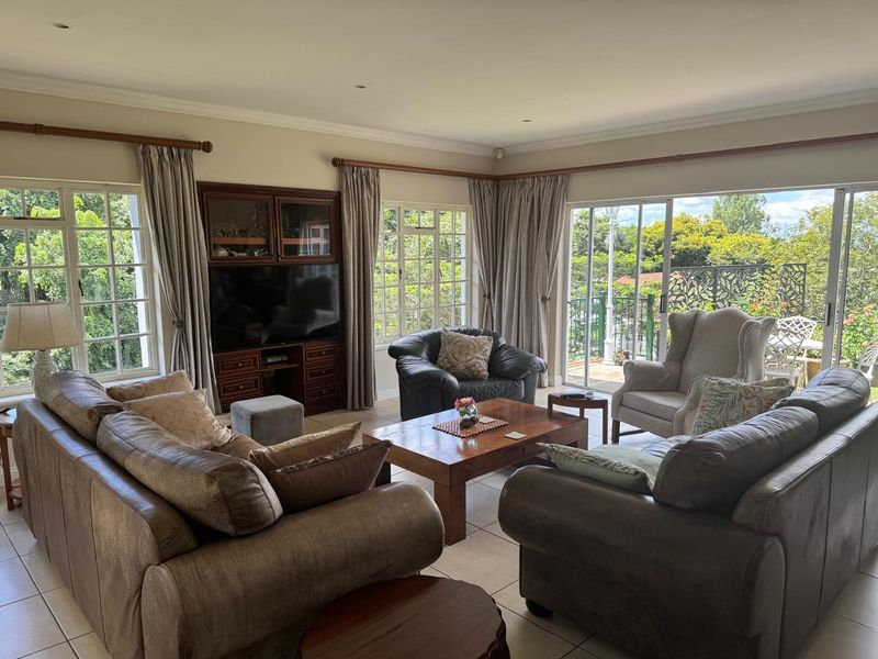 Spacious living room featuring built-in cabinetry, tiled flooring, and large sliding glass doors providing ample natural light and access to the outdoor area.