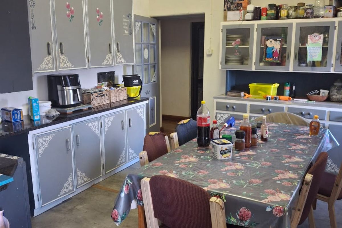 A functional kitchen area featuring built-in cabinetry, ample storage space, and a dedicated dining area, suitable for renovation or modernization.