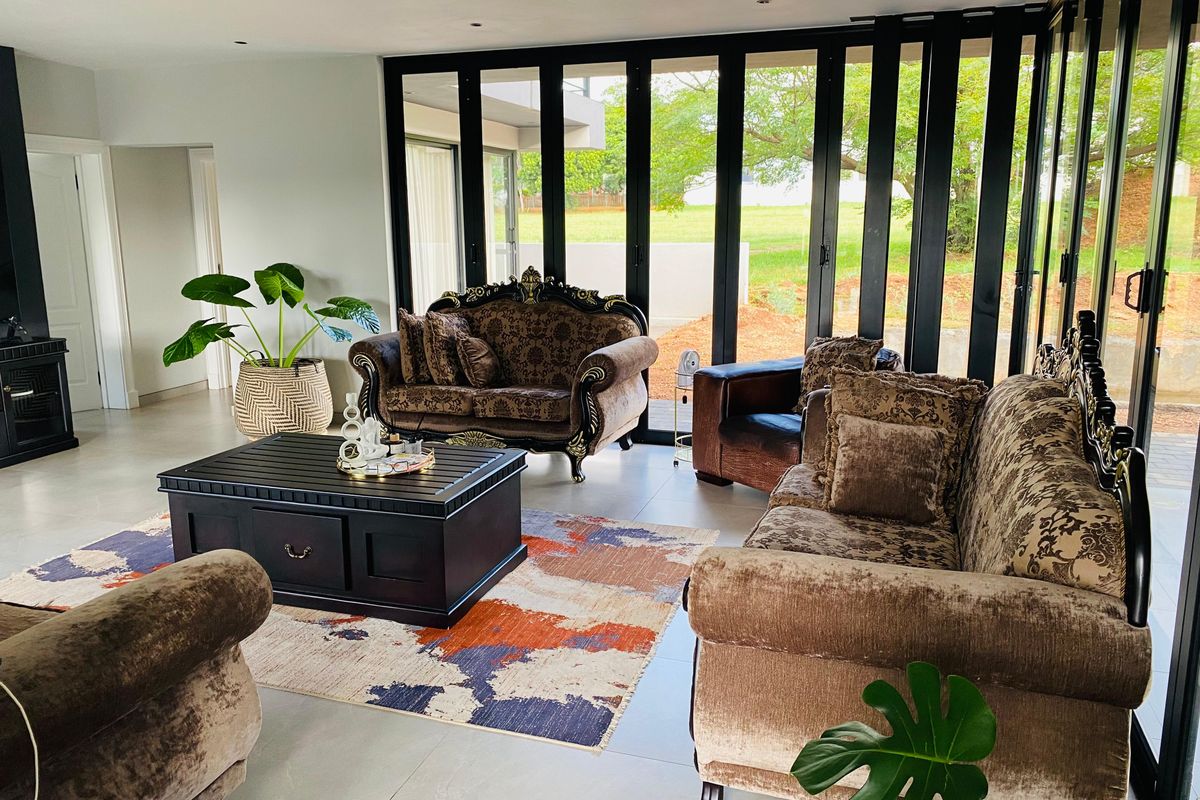 Spacious living room featuring large black-framed bi-fold doors that provide seamless indoor-outdoor flow and abundant natural light.