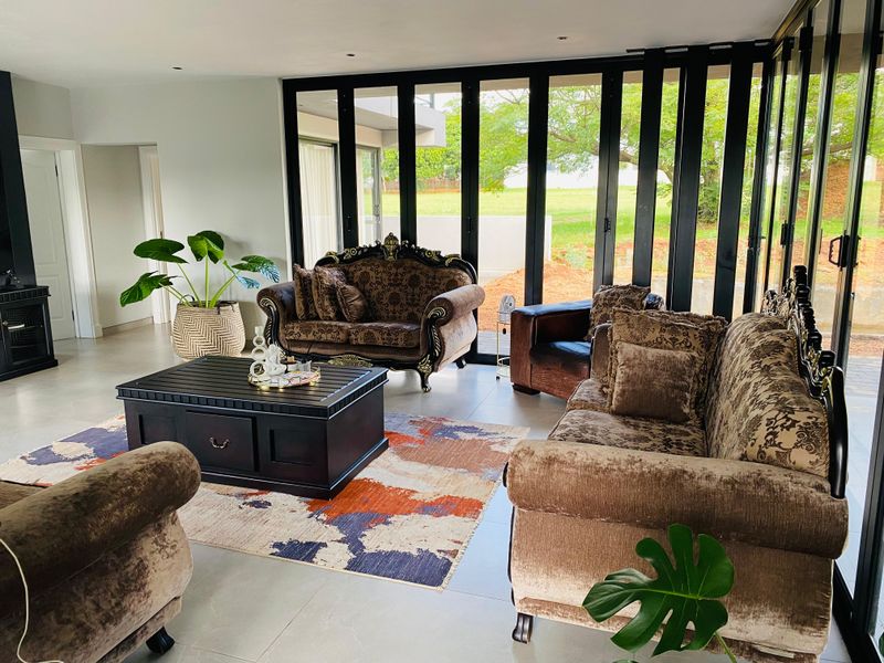 Spacious living room featuring large black-framed bi-fold doors that provide seamless indoor-outdoor flow and abundant natural light.