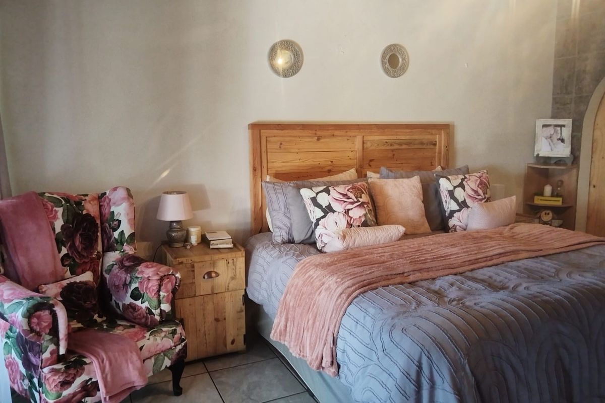 A cozy bedroom featuring tiled flooring and a wall-mounted air conditioning unit.