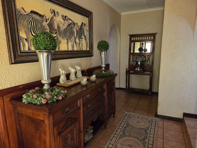 A welcoming entrance hall featuring textured wall finishes, tiled flooring, and an arched doorway leading to the interior living spaces.