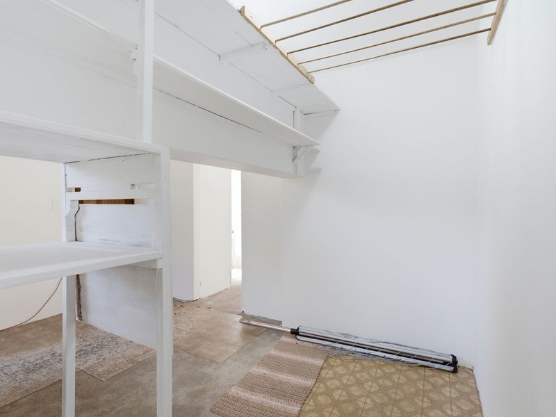 A functional laundry area featuring built-in shelving and a ceiling-mounted drying rack, providing a practical space for utility and storage needs.