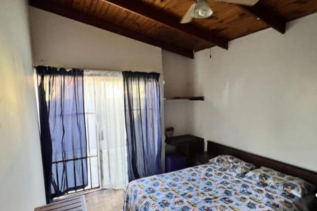 Bedroom featuring a vaulted timber-paneled ceiling, parquet flooring, and sliding glass doors providing access to the exterior.