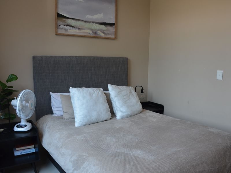 A well-maintained bedroom featuring neutral wall tones and a clean, functional layout.
