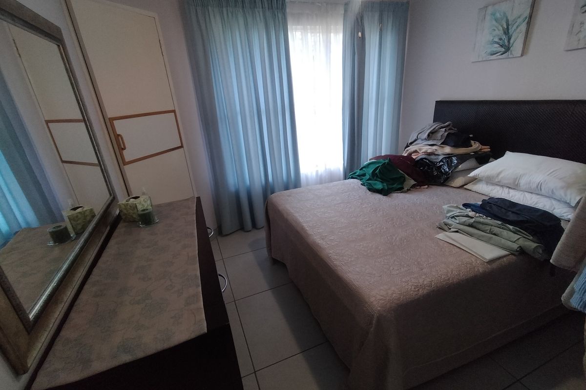 A functional bedroom featuring tiled flooring and a built-in cupboard, offering a neutral base for personalization.