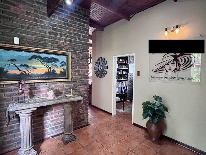 Entrance hall featuring a rustic exposed brick wall, warm timber ceiling, and durable ceramic floor tiles, creating a welcoming and character-filled transition space.