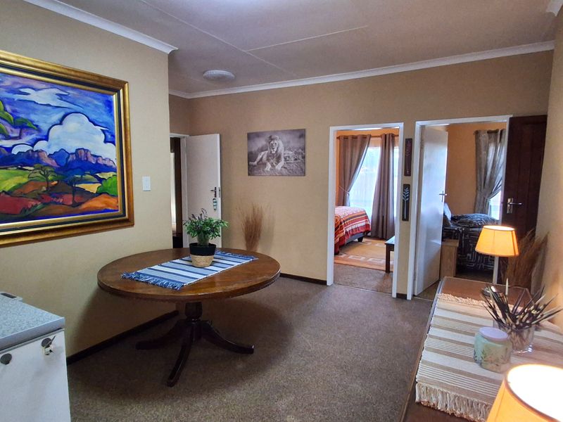 A functional hallway area providing access to adjacent bedrooms, featuring neutral wall tones and carpeted flooring.