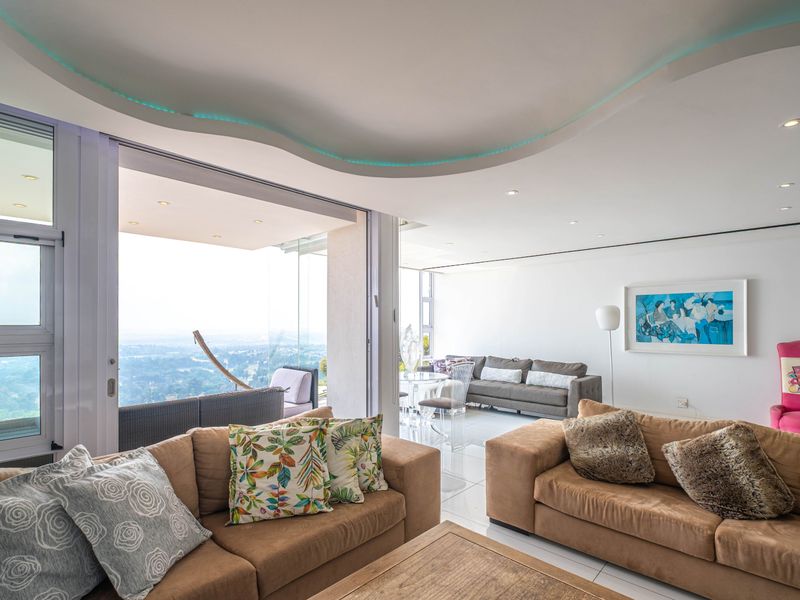 Spacious open-plan living area featuring a unique recessed ceiling design with integrated lighting, large sliding glass doors, and expansive views.