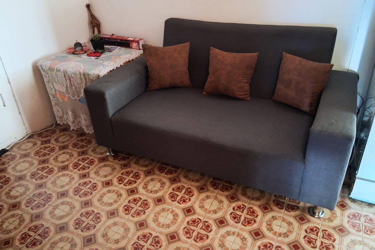 A living area featuring traditional patterned ceramic floor tiles and a neutral wall finish.