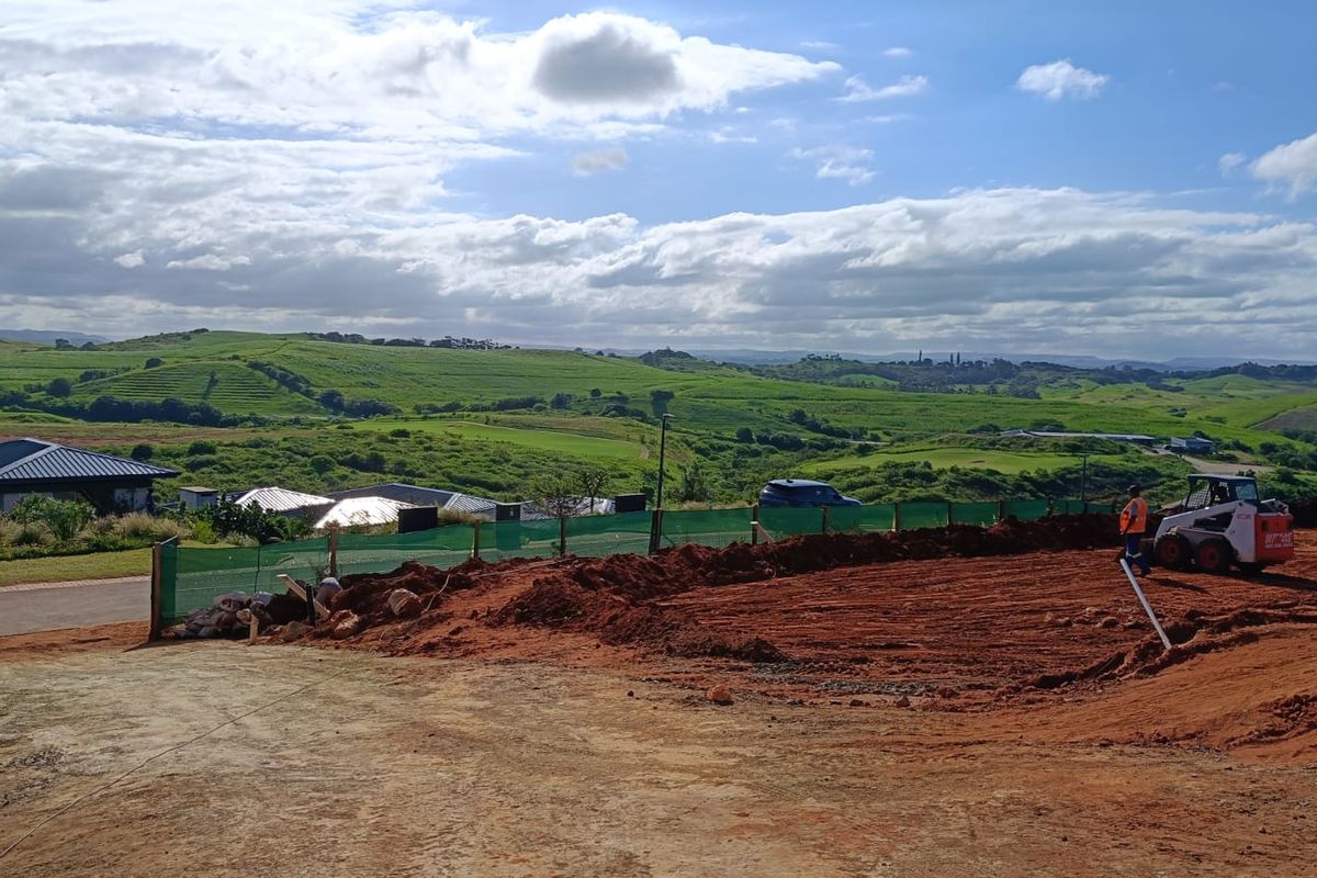 A construction site showing ongoing earthworks and site preparation with expansive rural landscape views in the background.