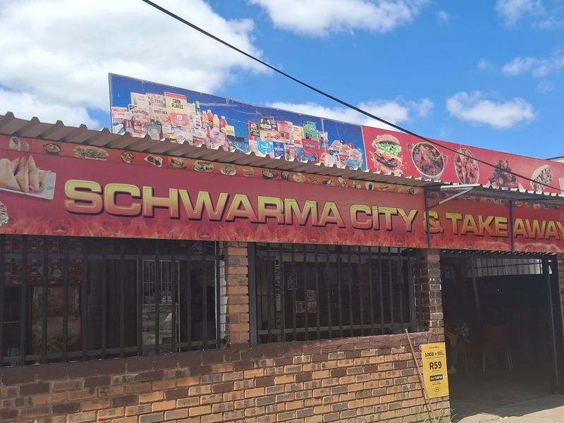 Front exterior view of a commercial takeaway property featuring brick construction, security bars, and prominent signage.