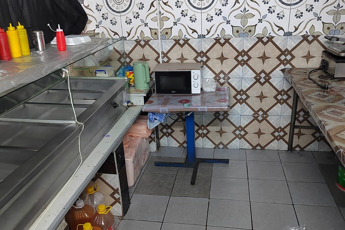 A functional kitchen area featuring patterned wall tiles, tiled flooring, and built-in food preparation equipment.