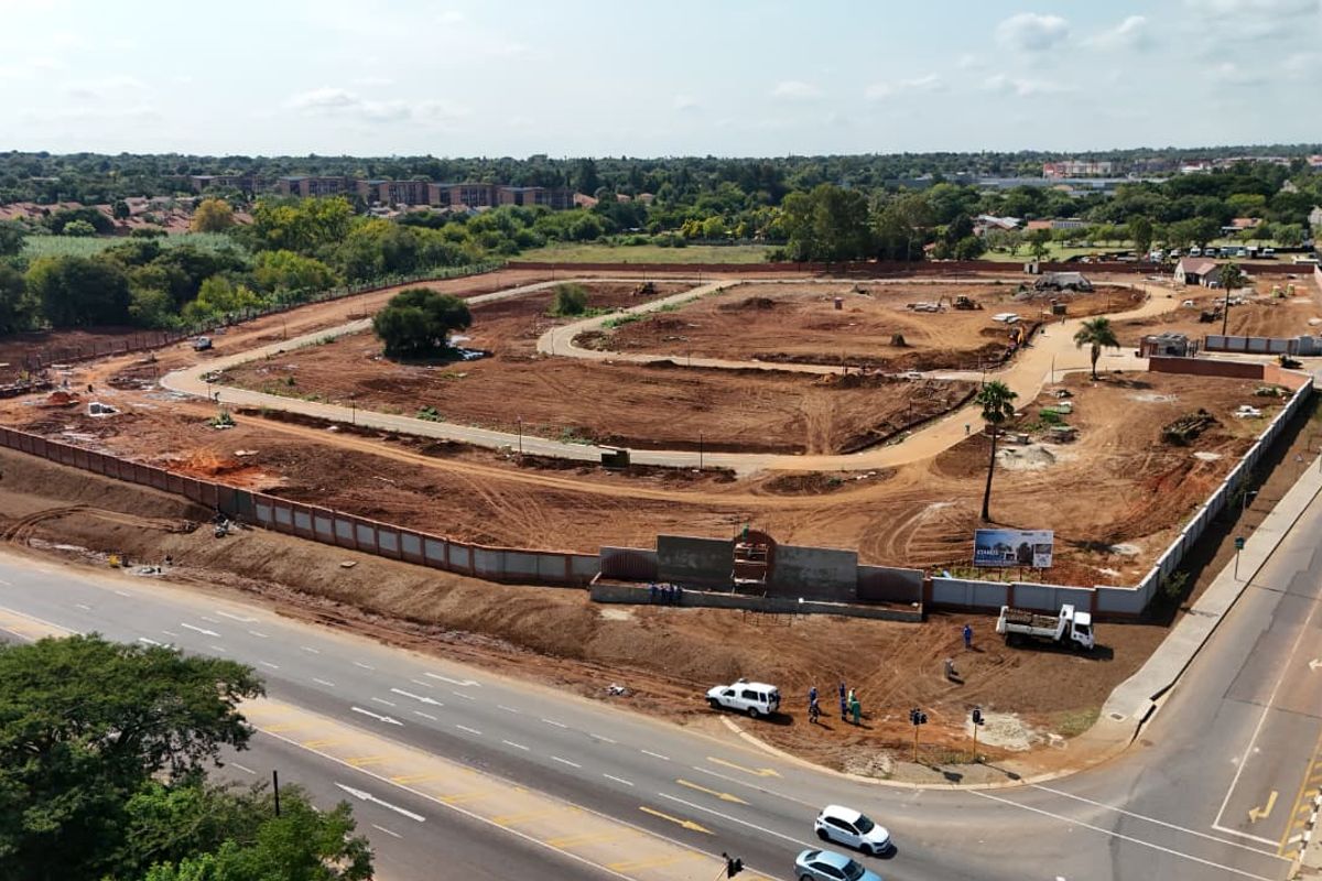 Aerial view of a residential development site showing cleared land, internal road layout, and perimeter fencing.