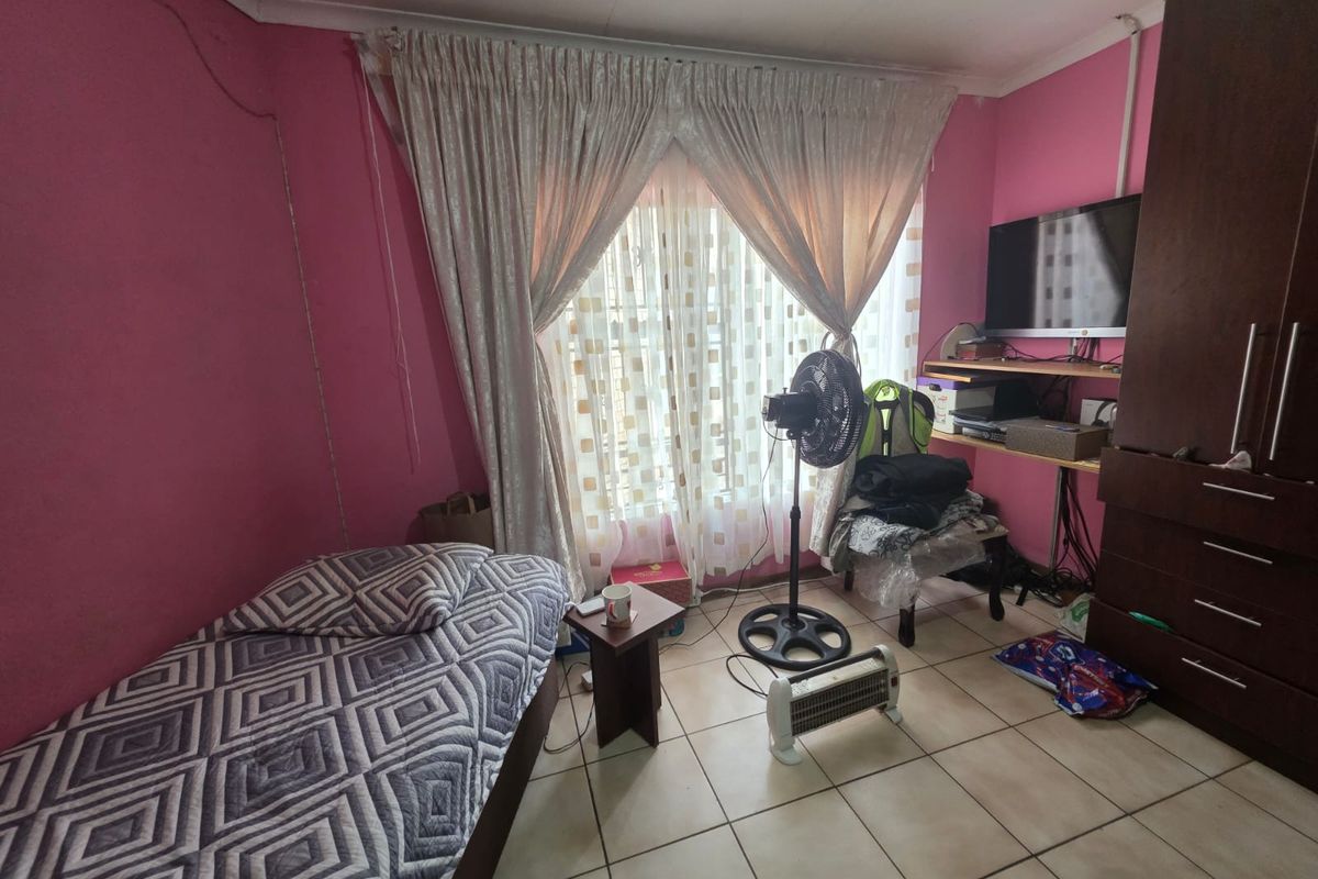 A bedroom featuring tiled flooring and built-in cabinetry, providing a functional space with potential for cosmetic updates.
