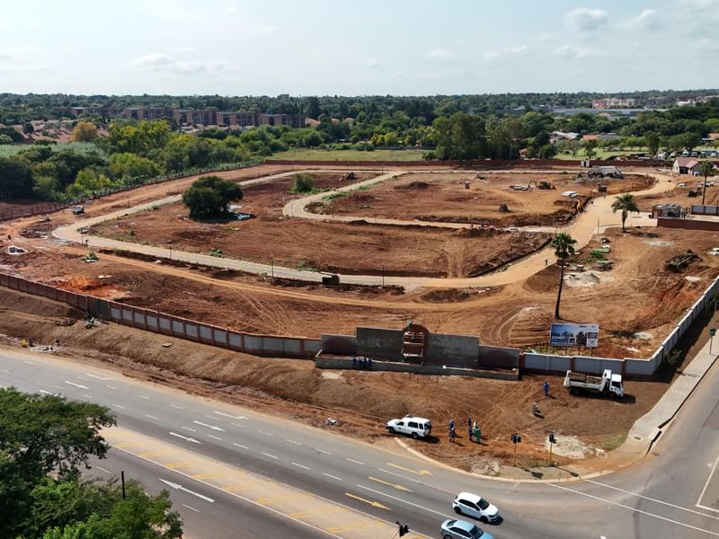 Aerial view of a residential development site showing cleared land, internal road layout, and perimeter fencing.