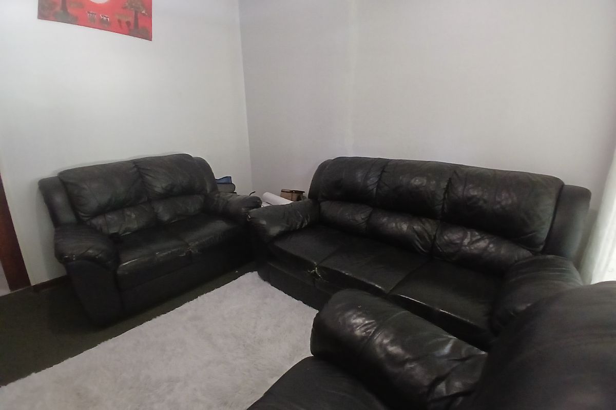 A standard living room area with neutral walls and carpeted flooring.